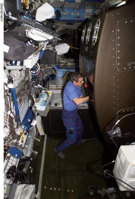 NASA image: McArthur removes AAA clamps and ducts inside the CHeCS Rack during Expedition 12