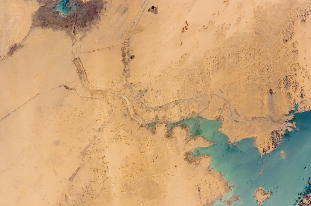ISS012-E-11654 (11 Dec. 2005) --- Lake Nasser and New Valley, Egypt are featured in this image photographed by an Expedition 12 crew member on the International Space Station. Cycles of flood and drought in the African Sahel are legendary, and they have provided the impetus for major waterworks on Africa’s great rivers. The construction of the Aswan High Dam on the Nile River, creating Lake Nasser in the 1960s, is the biggest and most visible project. Heavy rains in the source regions of the Nile in the 1990s resulted in record water levels in Lake Nasser. The abundance of water facilitated the Egyptian government’s promotion of another massive water distribution system called New Valley. In 1997, Lake Nasser flooded westward down a spillway into the Toshka depression in southern Egypt, creating four new lakes over the next few years. Following the initial flooding, a pumping station and canal were constructed in 2000 to maintain water flow into the region, allowing for industrial and agricultural development in the desert. This view shows the completed Mubarek Pumping Station on Lake Nasser; the spillway that originally flooded the Toshka depression and the southern end of the first of the Toshka Lakes; part of the 50-kilometer-long main canal (the Sheikh Zayed Canal); side canals; and several new fields in the Egyptian desert northwest of Lake Nasser. Astronauts, cosmonauts and space-based sensors have been monitoring these developments in Egypt since their inception in the late 1990s. New Valley’s Toshka Lakes, and the new developments surrounding them, represent one of the most visible and rapid man-made changes on Earth’s surface.