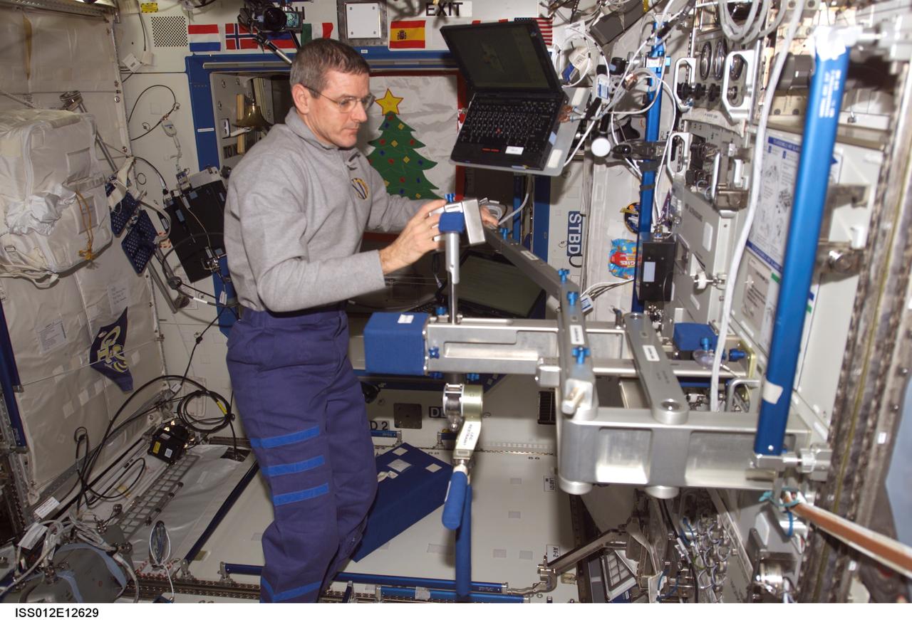 ISS012-E-12629 (16 Dec. 2005) --- Astronaut William S. (Bill) McArthur Jr., Expedition 12 commander and NASA space station science officer, sets up the calibration arm on the Space Linear Acceleration Mass Measurement Device (SLAMMD) attached to the Human Research Facility (HRF) rack in the Destiny laboratory of the International Space Station.