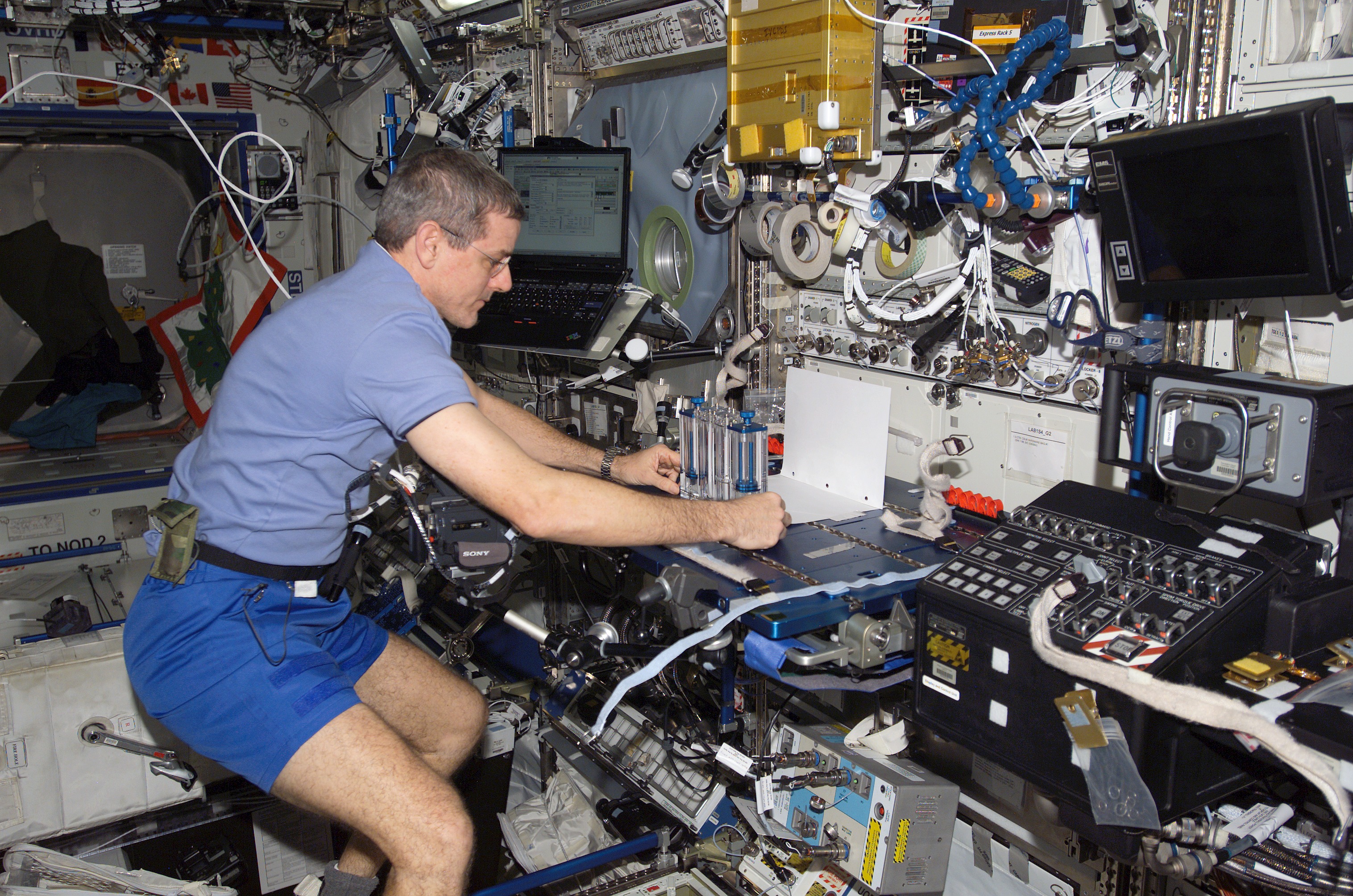 ISS012-E-12909 (20 Dec. 2005) --- Astronaut William S. (Bill) McArthur Jr., Expedition 12 commander and NASA space station science officer, prepares the Capillary Flow Experiment (CFE) for video documentation. The CFE was positioned on the Maintenance Work Area in the Destiny laboratory of the International Space Station.