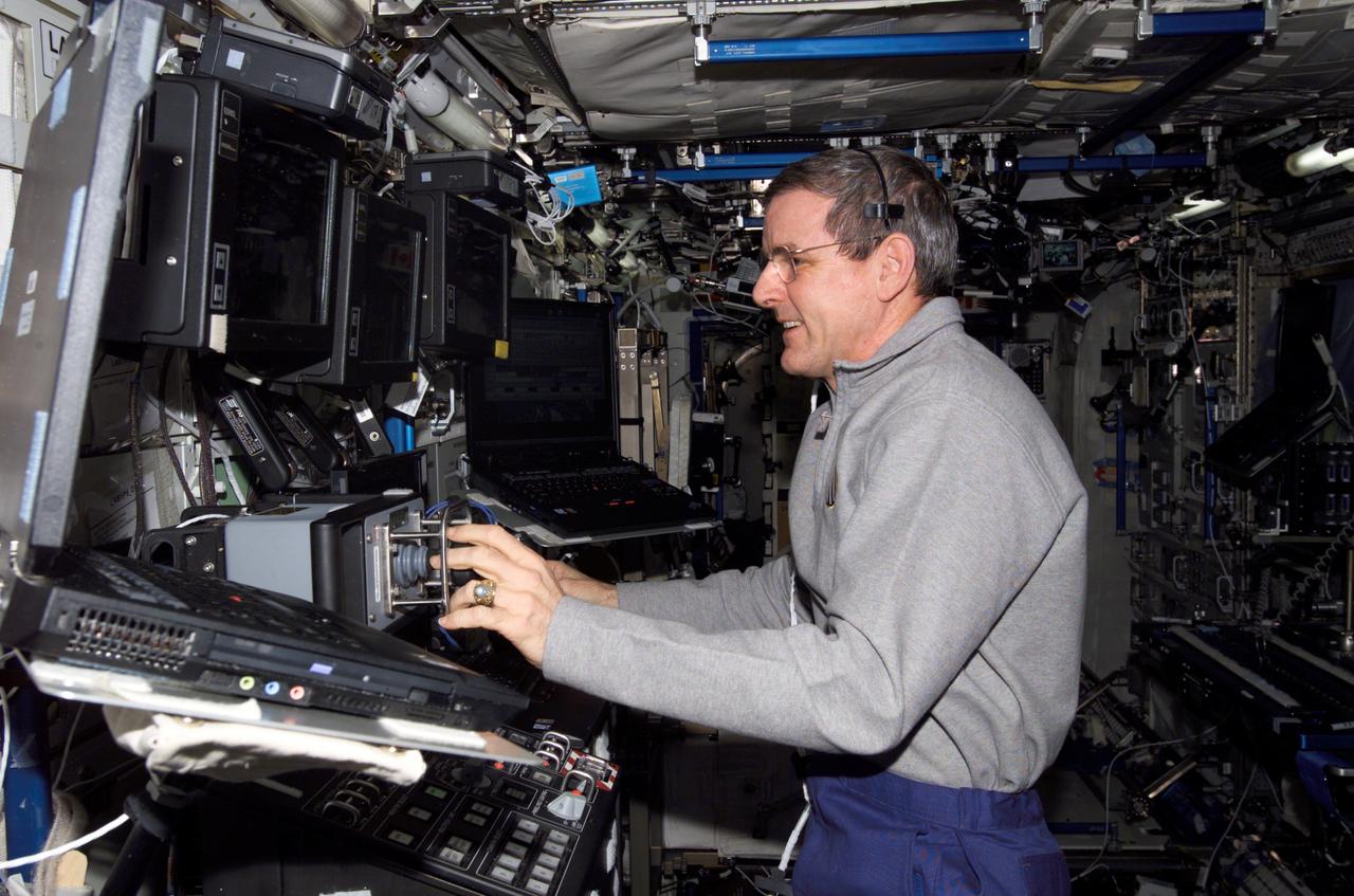 ISS012-E-14993 (12 Jan. 2006) --- Astronaut William S. (Bill) McArthur, Expedition 12 commander and NASA space station science officer, maneuvers the Space Station Remote Manipulator System (SSRMS) or Canadarm2 during a video inspection of the Mobile Transporter (MT) Interface Umbilical Assembly 1 (IUA) using the Dynamic Onboard Ubiquitous Graphics (DOUG) software in the Destiny laboratory of the International Space Station.
