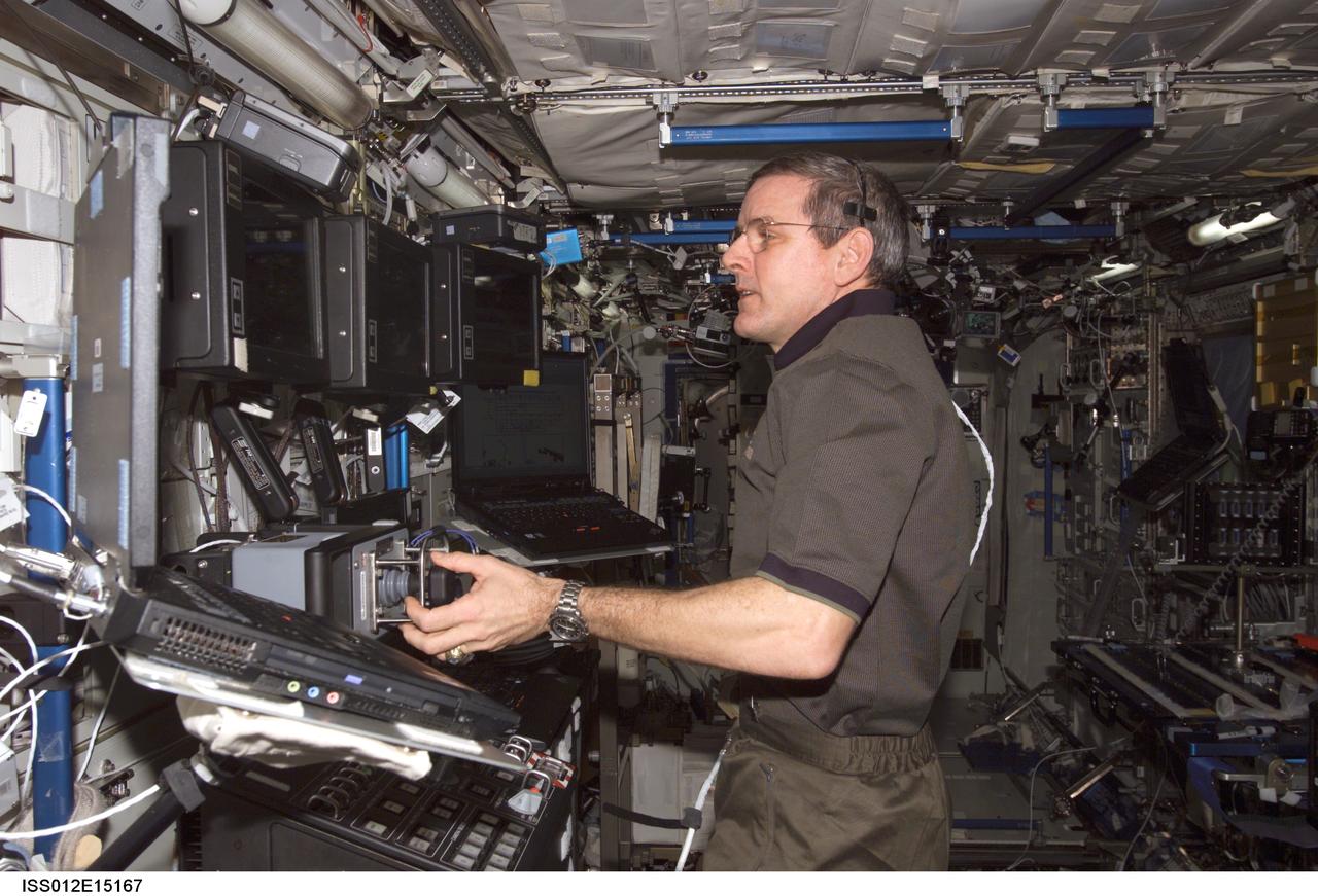 ISS012-E-15167 (13 Jan. 2006) --- Astronaut William S. (Bill) McArthur, Expedition 12 commander and NASA space station science officer, maneuvers the Space Station Remote Manipulator System (SSRMS) or Canadarm2 in the Destiny laboratory of the International Space Station during a survey of the Unity node Nadir Active Common Berthing Mechanism (ACBM) to look for possible debris or damage on the sealing surface.