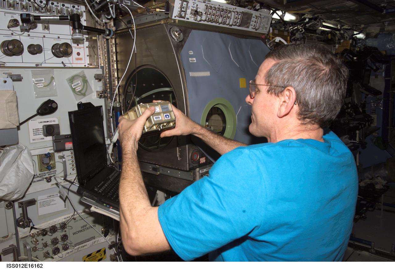 ISS012-E-16162 (18 Jan. 2006) --- Astronaut William S. (Bill) McArthur, Expedition 12 commander and NASA space station science officer, configures the Microgravity Science Glovebox (MSG) facility to prepare for the installation and activation of the Protein Crystal Growth Monitoring by Digital Holographic Microscope (PromISS) experiment in the Destiny laboratory on the International Space Station.
