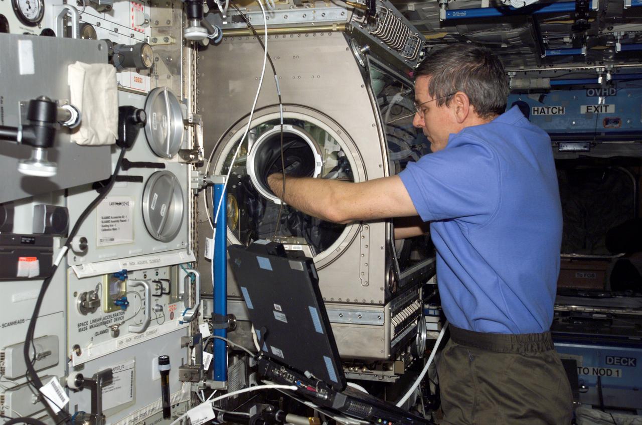 ISS012-E-16237 (19 Jan. 2006) --- Astronaut William S. (Bill) McArthur, Expedition 12 commander and NASA space station science officer, configures the Microgravity Science Glovebox (MSG) facility to prepare for the installation and activation of the Protein Crystal Growth Monitoring by Digital Holographic Microscope (PromISS) experiment in the Destiny laboratory on the International Space Station.