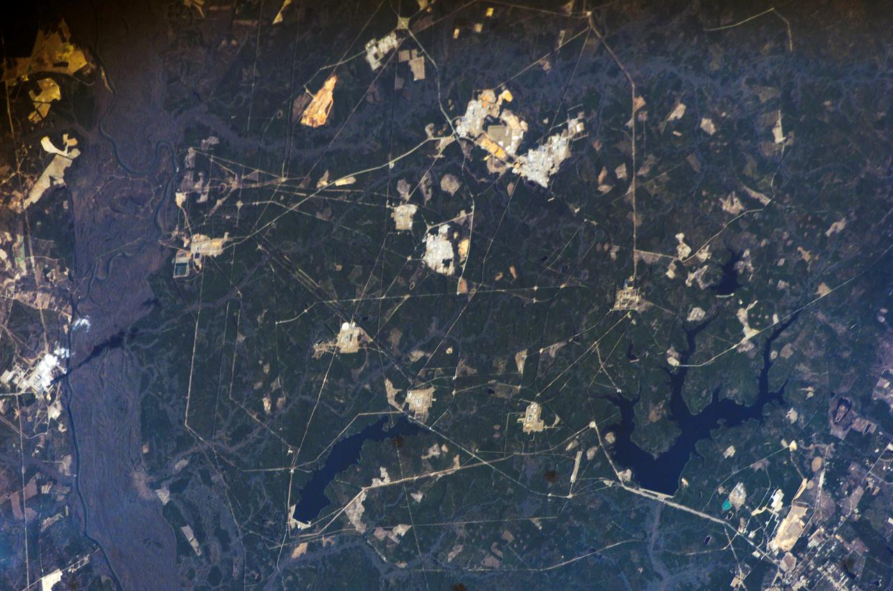 ISS012-E-16633 (28 Jan. 2006) --- Savannah River Site, South Carolina is featured in this image photographed by an Expedition 12 crew member on the International Space Station. Situated between the South Carolina piedmont and the Atlantic Ocean, the Savannah River Site is an important part of the US Department of Energy&#0146;s nuclear program. Construction of the site &#0150; originally called the Savannah River Plant &#0150; began in 1951 for the purpose of generating radioactive materials, primarily the hydrogen isotope tritium and plutonium-239, necessary for nuclear weapons production during the Cold War. A total of five nuclear reactors occupy the central portion of the site and operated throughout 1953-1992. Following the end of the Cold War in 1991 activities at the Savannah River Site are now focused on disposal of nuclear wastes, environmental cleanup of the site itself, and development of advanced remediation technologies. The Savannah River Site is located in the Sand Hills region of South Carolina and includes an area of 800 square kilometers (300 square miles). The southern half of the Site (building clusters with reflective white rooftops) is shown. The nearby Savannah River and its tributary creeks provided a ready source of water for the nuclear reactors; to this end, two artificial lakes (&#0147;L&#0148; Lake and Par Pond) were constructed. The meandering channel of the River and its floodplain, characterized by grey-brown sediments, extends from northwest to southeast across the left portion of the image. The proximity of the River, and the permeable nature of the geological materials under laying the site (sand, clay, gravel, and carbonate rocks), necessitate extensive and ongoing environmental monitoring and cleanup efforts to reduce potential contamination of local water sources. According to NASA scientists, final remediation of wastes posing threats to surface and groundwater is scheduled to occur by 2025.