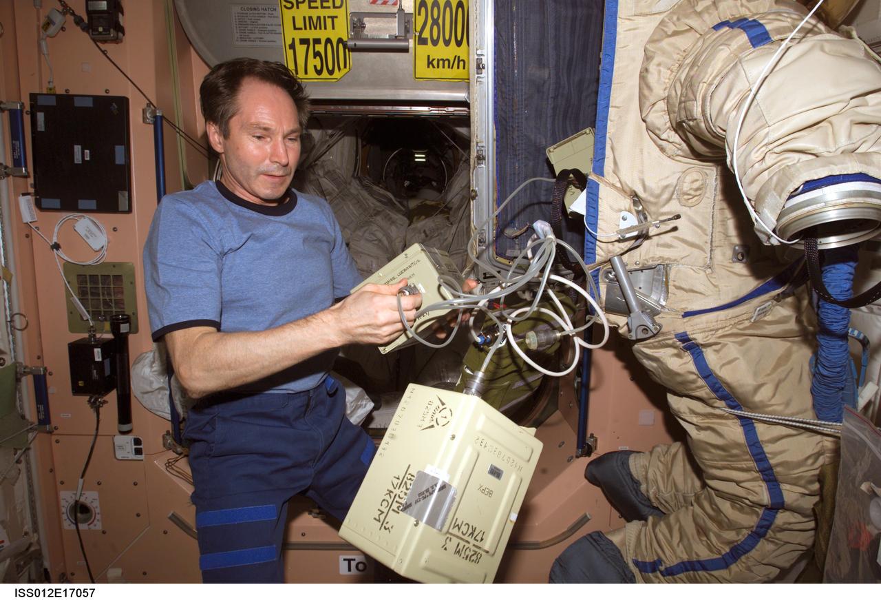ISS012-E-17057 (24 Jan. 2006) --- In the Unity node of the International Space Station, cosmonaut Valery I. Tokarev, Expedition 12 flight engineer representing Russia's Federal Space Agency, puts finishing touches on an old Russian Orlan spacesuit that will be released by hand from the space station during a spacewalk Feb. 3, 2006. Outfitted with a special radio transmitter and other gear, the spacesuit comprises a Russian experiment called SuitSat. It will fly free from the station as a satellite in orbit for several weeks of scientific research and radio tracking, including communications by amateur radio operators. Eventually, it will enter the atmosphere and be destroyed.