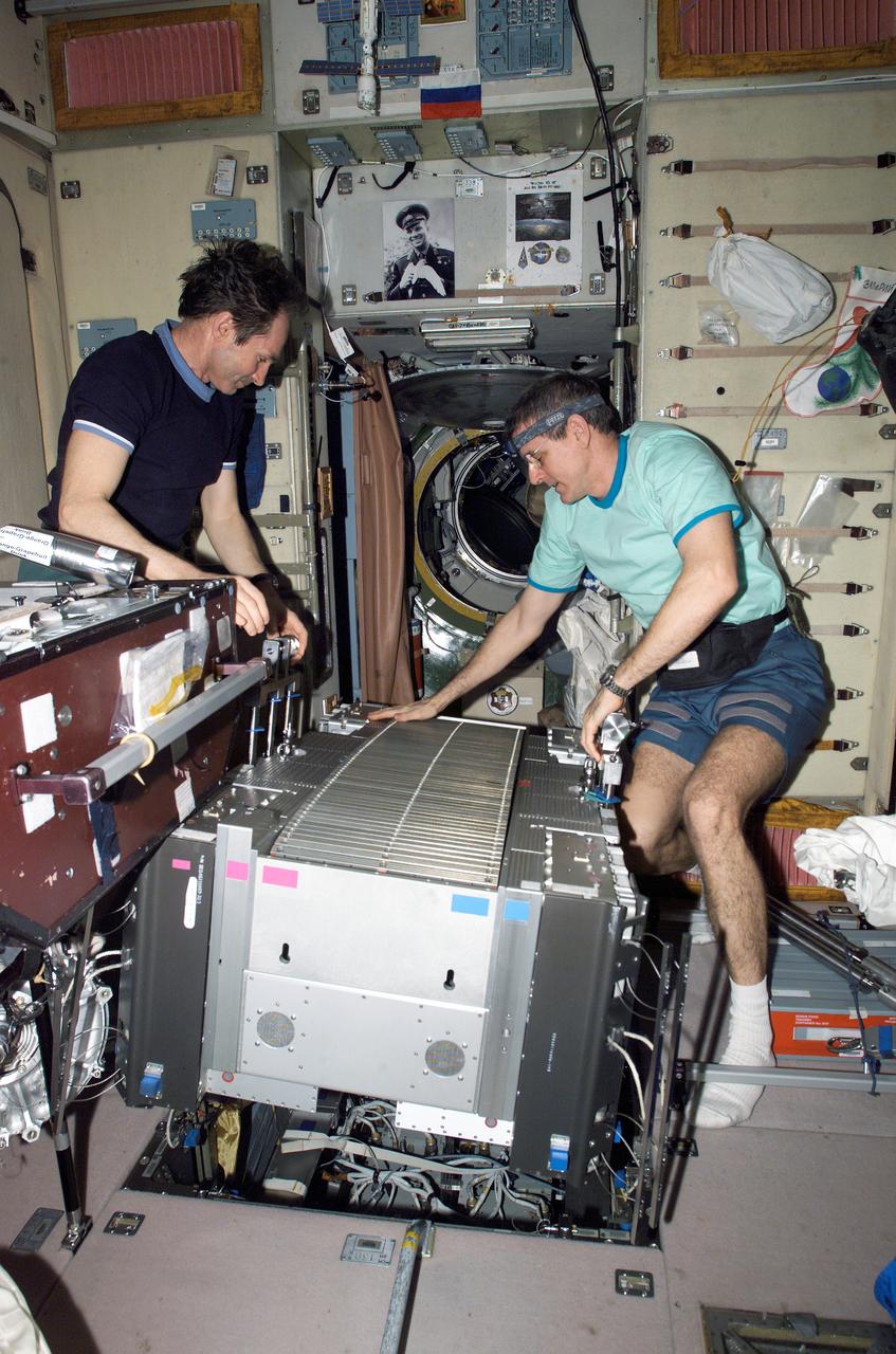 ISS012-E-18234 (14 Feb. 2006) --- Astronaut William S. (Bill) McArthur, Jr. (right), Expedition 12 commander and NASA space station science officer, and cosmonaut Valery I. Tokarev, flight engineer representing Russia's Federal Space Agency, work with the Treadmill Vibration Isolation System (TVIS) in the Zvezda Service Module of the International Space Station.