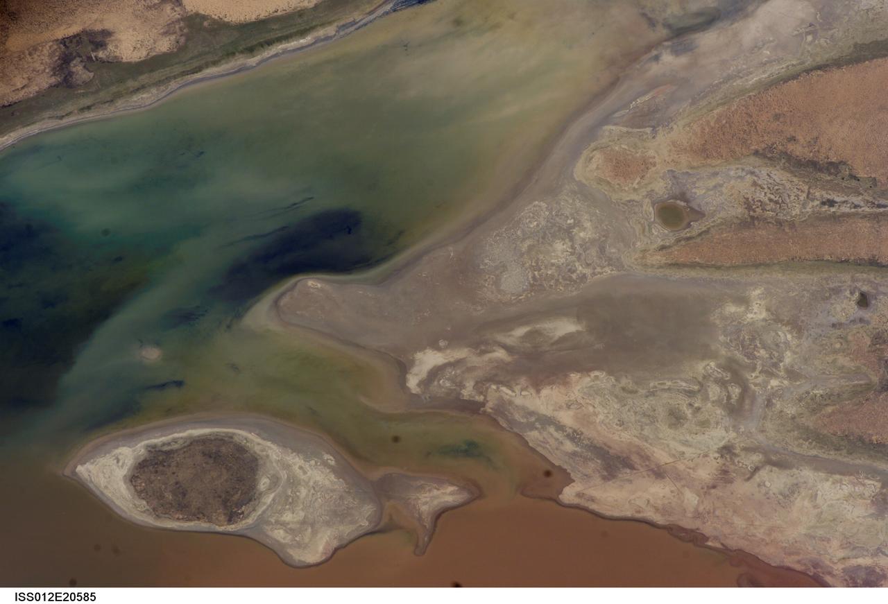 ISS012-E-20585 (9 March 2006) --- A portion of Lake Poopo is featured in this image photographed by an Expedition 12 crewmember on the International Space Station. Lake Poopo sits high in the Bolivian Andes, catching runoff from its larger neighbor to the north - Lake Titicaca (not shown) - by way of the Desaguadero River (muddy area at the north end of the lake). Because Lake Poopo is very high in elevation (roughly 3400 meters or 11,000 feet above sea level), very shallow (generally less than 3 meters or 9 feet), and the regional climate is very dry, small changes in precipitation in the surrounding basin have large impacts on the water levels and areal extent of Lake Poopo. When the lake fills during wet periods, Poopo drains from the south end into Salar de Coipasa (not shown). Water levels in Poopo are important because it is one of South America’s largest saline lakes, and a prime stop for migratory birds, including flamingoes. Last November, water levels had dropped, exposing large tracts of salt and mud flats. A wet and cool period between December and the end of February resulted in flooding of Poopo with muddy waters from the Desaguadero River. NASA managers have tasked the station crew to track such changes, which are related to regional weather patterns. Lake Poopo’s sensitivity to precipitation in the high Andes (possibly reflecting larger climate cycles) provides an excellent visual indicator of these trends.