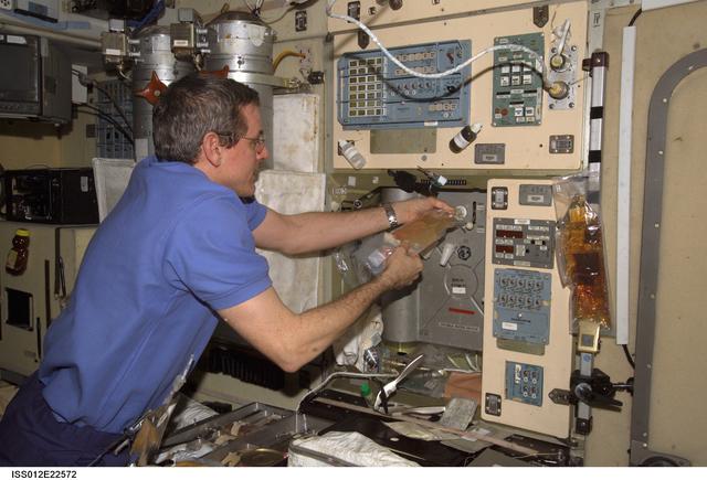 NASA image: McArthur hydrates a juice drink using the potable water heater on Expedition 12