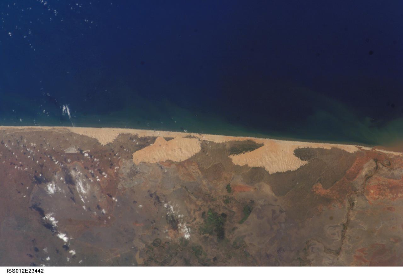 ISS012-E-23442 (2 Dec. 2005) --- The coastal region in Somalia, south of the capital of Mogadishu (out of frame), is featured in this image photographed during normal conditions by an Expedition 12 crewmember on the International Space Station. An image captured during the Expedition 14 mission (ISS014-E-13848) shows the same coastal region with contrasting wet conditions.