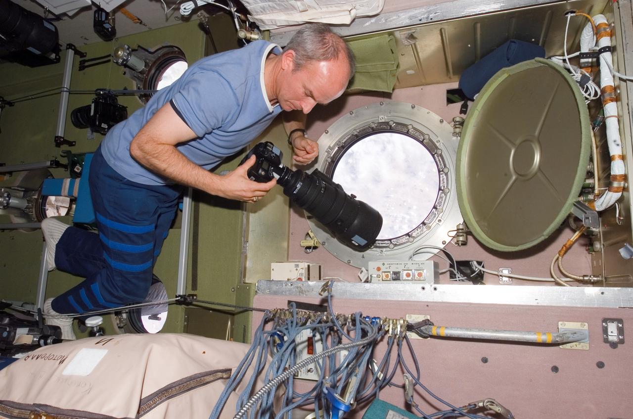Williams prepares to take pictures at the SM window during Expedition 13