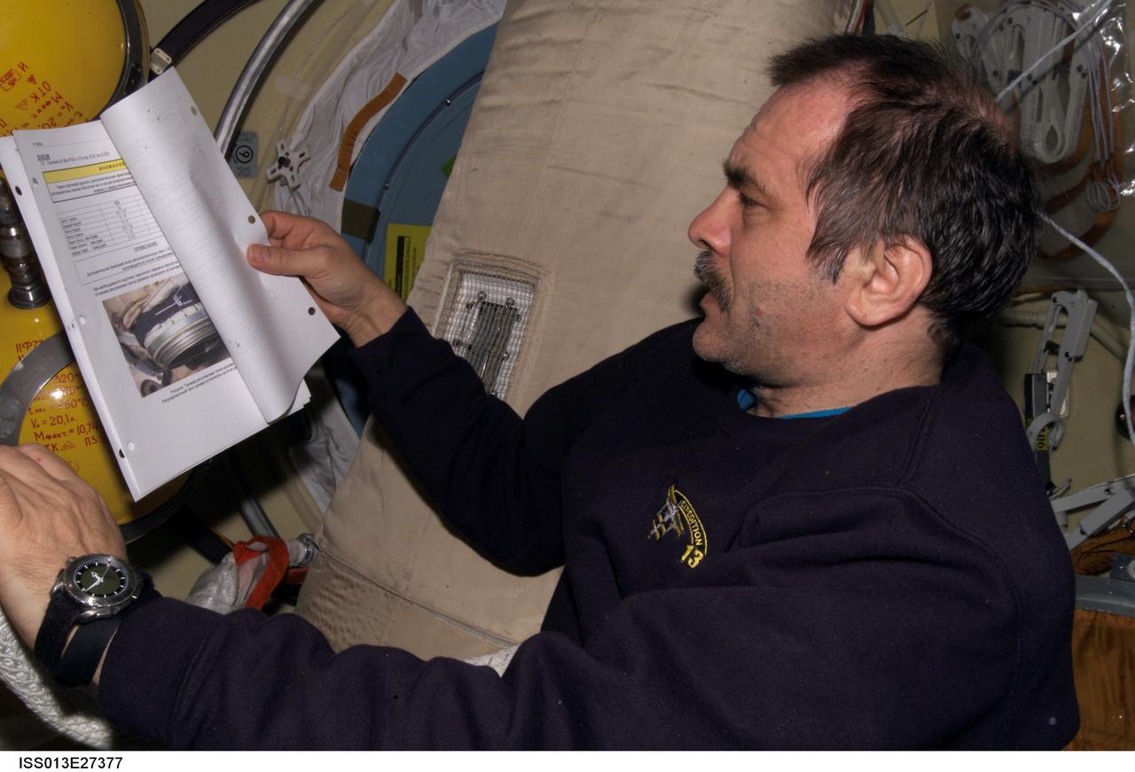 ISS013-E-27377 (26 May 2006) --- Cosmonaut Pavel V. Vinogradov, Expedition 13 commander representing Russia's Federal Space Agency, looks over a procedures checklist in the Zvezda Service Module of the International Space Station.