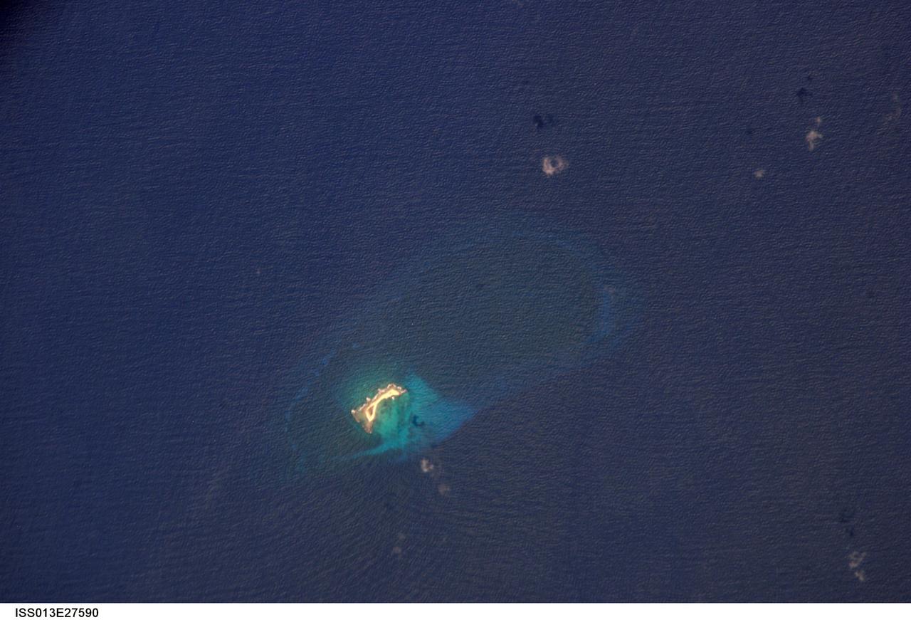 ISS013-E-27590 (27 May 2006) --- Aves Island, Caribbean Sea is featured in this image photographed by an Expedition 13 crewmember on the International Space Station. This image is a rare almost cloud free view of the island and the submerged fringing coral reef that surrounds it. Scientists believe the crosshatch-like pattern of roughness on the surrounding sea surface was caused by variable winds at the time of image acquisition. The island itself currently stands a mere 4 meters above the surrounding sea surface, and in high seas it can be completely submerged. While the low elevation of the island makes it a hazard to shipping, it also provides a major nesting site for green sea turtles (Chelonia mydas) in the Caribbean.
