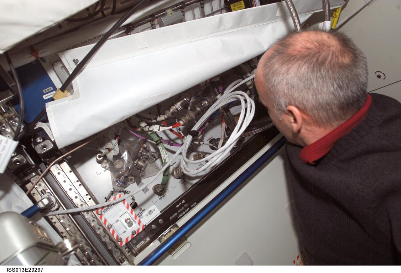 ISS013-E-29297 (1 June 2006) --- Astronaut Jeffrey N. Williams, Expedition 13 NASA space station science officer and flight engineer, performs in-flight maintenance on a Thermal Control System (TCS) line on an open rack in the Destiny laboratory of the International Space Station.