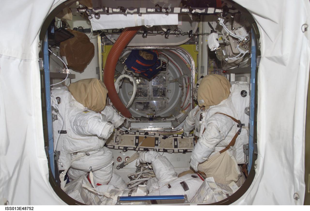 ISS013-E-48752 (6 July 2006) --- In the quest airlock on the International Space Station, two extravehicular mobility unit space suits await a busy day of spacewalking in a couple of days when astronauts Michael E. Fossum and Piers J. Sellers don them, marking the first of three planned sessions of extravehicular activity for the STS-121 crew.