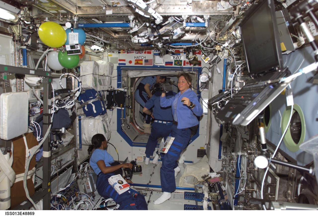 ISS013-E-48869 (6 July 2006) --- Astronauts Stephanie D. Wilson (left) and Lisa M. Nowak, both missions for STS-121, check out camera gear during their personal inaugural space flights and during their first day onboard the International Space Station.