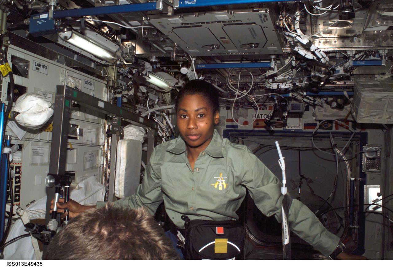 ISS013-E-49435 (9 July 2006) --- Astronaut Stephanie D. Wilson, STS-121 mission specialist, floats in the Destiny laboratory of the International Space Station. A beverage container floats freely at right.