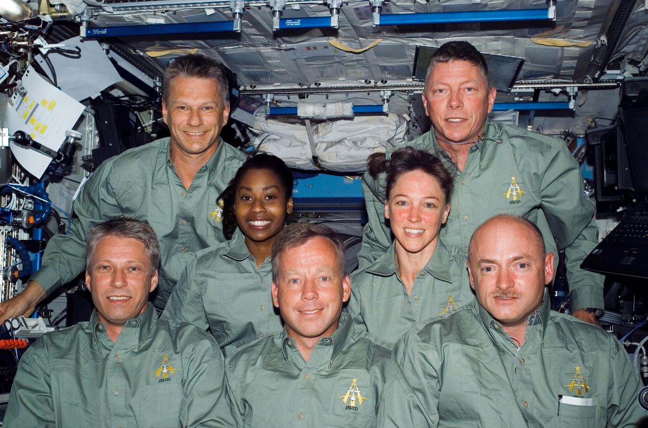 ISS013-E-49464 (9 July 2006) --- European Space Agency (ESA) astronaut Thomas Reiter, new Expedition 13 crewmember, and the STS-121 crew gather for an in-flight portrait in the Destiny laboratory of the International Space Station. From the left (front row) are Reiter, astronauts Steven W. Lindsey, commander; and Mark E. Kelly, pilot. From the left (middle row) are astronaut Stephanie D. Wilson and Lisa M. Nowak, both mission specialists. From the left (back row) are astronauts Piers J. Sellers and Michael E. Fossum, both mission specialists. Reiter launched on the Space Shuttle Discovery with the STS-121 crew and officially became an Expedition 13 crewmember after the shuttle docked with the station.