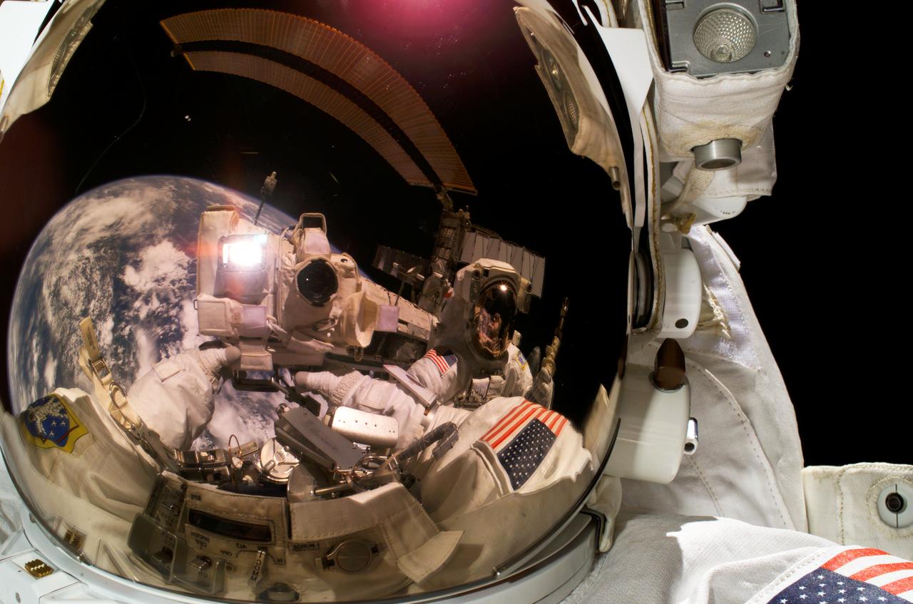 ISS013-E-49645 (8 July 2006) --- Astronaut Michael E. Fossum, STS-121 mission specialist, used a digital still camera to expose a photo of his helmet visor during today's session of extravehicular activity (EVA) while Space Shuttle Discovery was docked with the International Space Station. Also visible in the reflections in the visor are fellow spacewalker Piers J. Sellers, mission specialist, Earth's horizon and a station solar array.