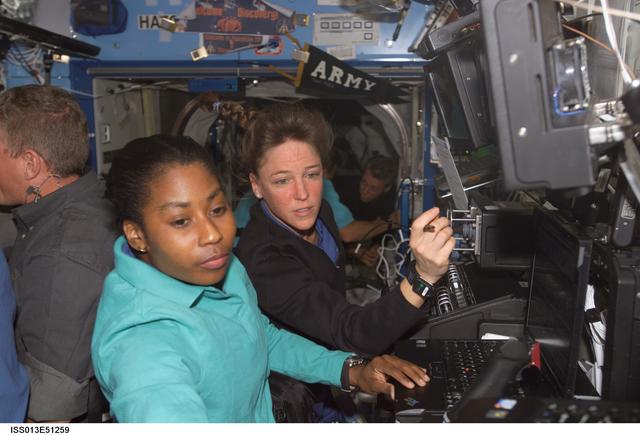 NASA image: Nowak and Wilson work at a RWS during Expedition 13 / STS-121 joint operations