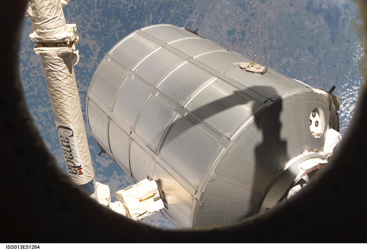 ISS013-E-51264 (14 July 2006) --- Canadarm2 or the Space Station Remote Manipulator System (SSRMS) arm grasps the Italian-built Multi-Purpose Logistics Module Leonardo to place it back in Discovery's cargo bay. On the other end of the arm, inside the shirt sleeve environment of the Destiny laboratory on the International Space Station, astronauts Stephanie D. Wilson and Lisa M. Nowak, STS-121 mission specialists, were in control of the transfer. The MPLM was being moved from its temporary parking place on the station's Unity node to the payload bay of Discovery for the return trip to Earth.