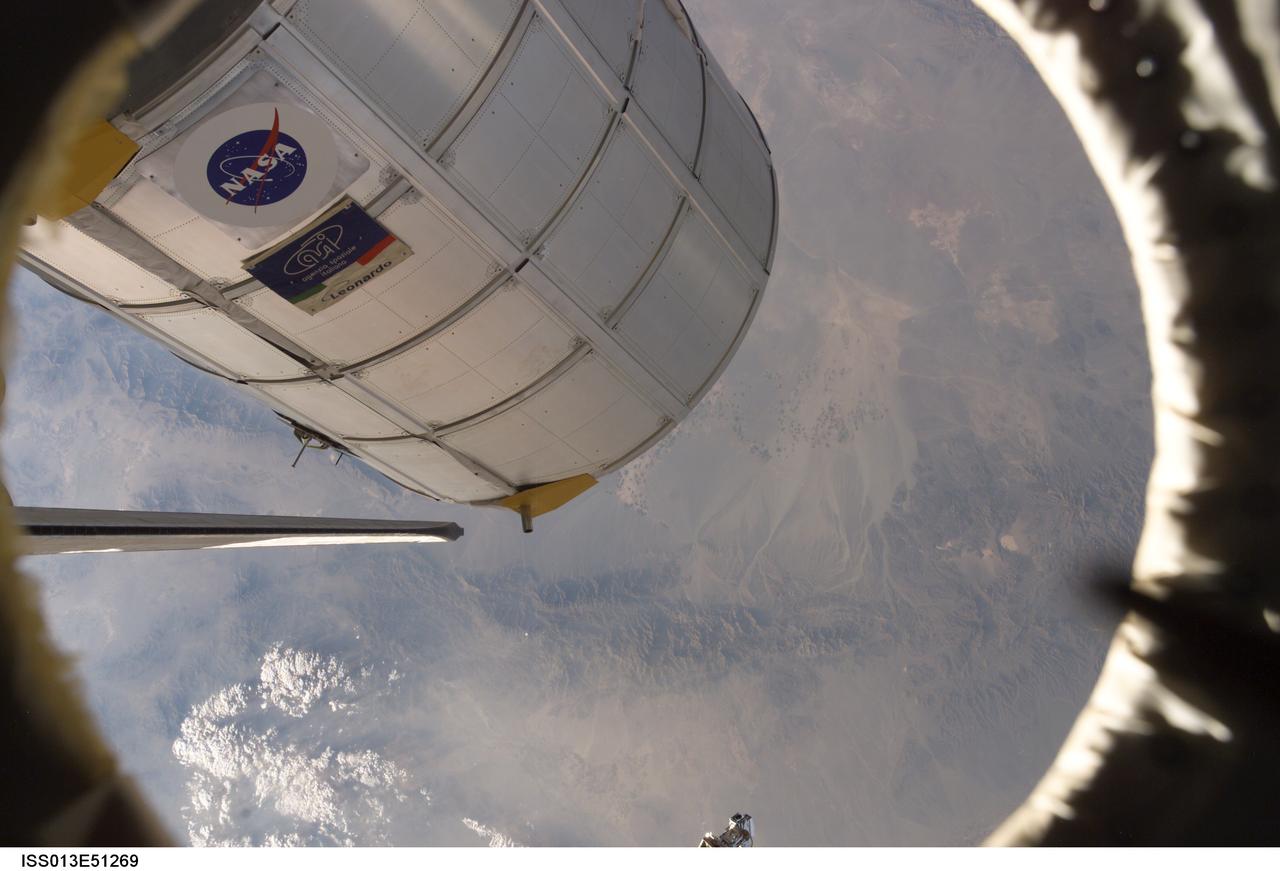 ISS013-E-51269 (14 July 2006) --- Canadarm2 or the Space Station Remote Manipulator System (SSRMS) arm (out of frame) grasps the Italian-built Multi-Purpose Logistics Module Leonardo to place it back in Discovery's cargo bay. On the other end of the arm, inside the shirt sleeve environment of the Destiny laboratory on the International Space Station, astronauts Stephanie D. Wilson and Lisa M. Nowak, STS-121 mission specialists, were in control of the transfer. The MPLM was being moved from its temporary parking place on the station's Unity node to the payload bay of Discovery for the return trip to Earth. Discovery's vertical stabilizer is at left.