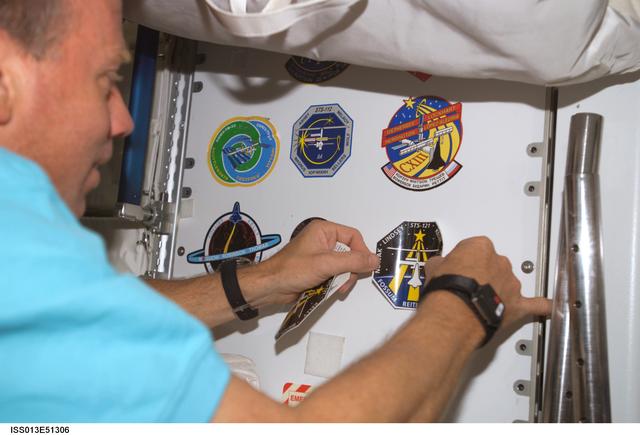 NASA image: Lindsey place an STS-121 mission insignia patch on locker in the U S Lab during Expedition 13 / STS-121 joint operations