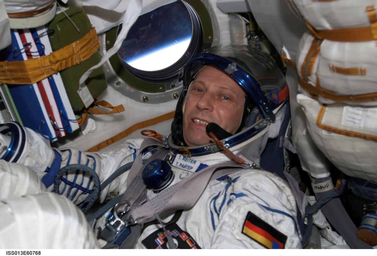 ISS013-E-60768 (26 July 2006) --- Attired in a Russian Sokol launch and entry suit, European Space Agency (ESA) astronaut Thomas Reiter, Expedition 13 flight engineer, participates in a Kazbek couch fit check in the TMA-8 Soyuz spacecraft docked to the International Space Station.
