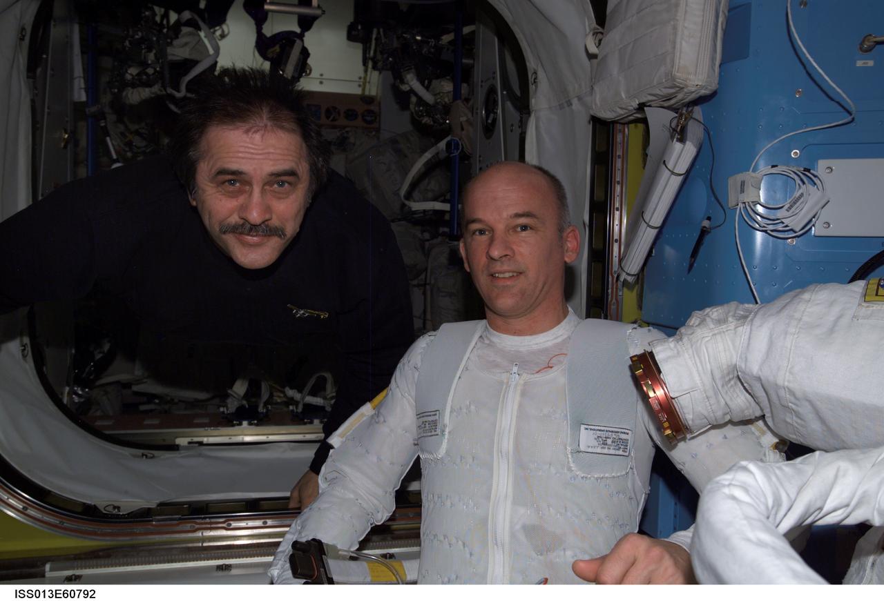 ISS013-E-60792 (28 July 2006) --- Cosmonaut Pavel V. Vinogradov (left), Expedition 13 commander representing Russia's Federal Space Agency, and astronaut Jeffrey N. Williams, NASA space station science officer and flight engineer, take a moment to pose for a photo in the Quest Airlock of the International Space Station. Williams is attired in a liquid cooling and ventilation garment that complements the Extravehicular Mobility Unit (EMU) space suit. The crew is preparing for a session of extravehicular activity (EVA) scheduled for Thursday, Aug. 3, 2006.