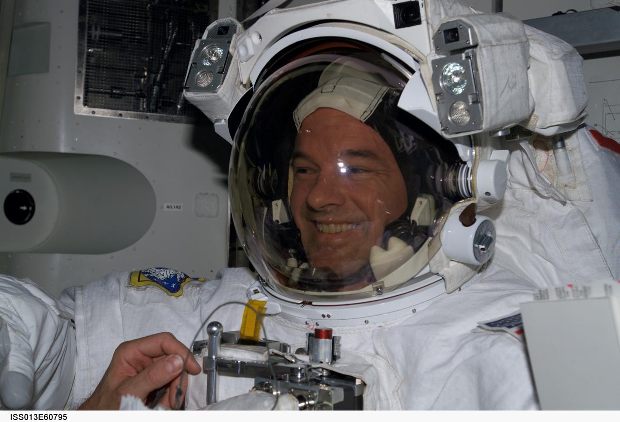 ISS013-E-60795 (28 July 2006) --- Attired in his Extravehicular Mobility Unit (EMU) space suit, astronaut Jeffrey N. Williams, Expedition 13 NASA space station science officer and flight engineer, prepares for a session of extravehicular activity (EVA) scheduled for Thursday, Aug. 3, 2006. Williams is in the Quest Airlock of the International Space Station.