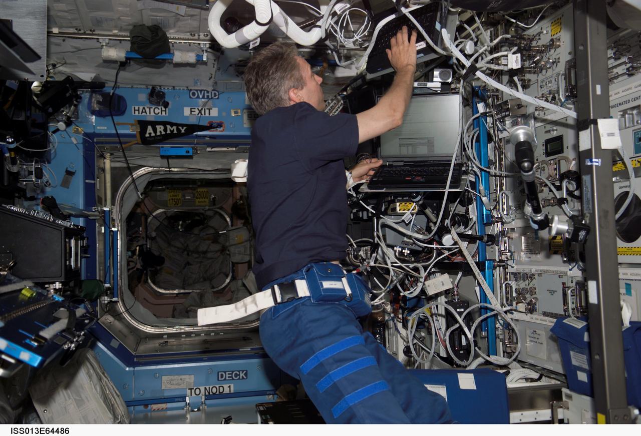 ISS013-E-64486 (25 July 2006) --- European Space Agency (ESA) astronaut Thomas Reiter, Expedition 13 flight engineer, prepares the Human Research Facility (HRF-2) rack for the scheduled upgrade of the Pulmonary Function System (PFS) experiment in the Destiny laboratory of the International Space Station.