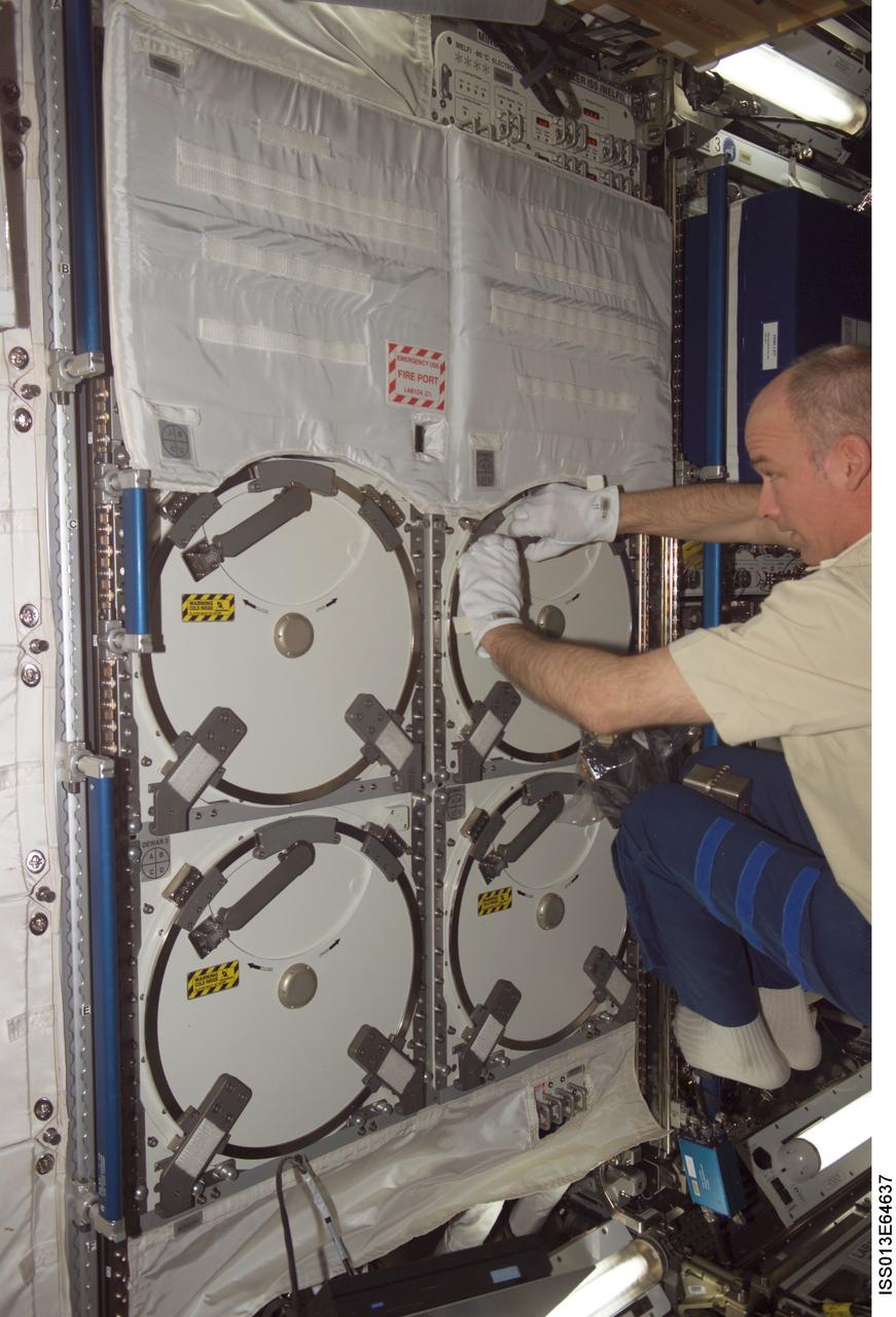 ISS013-E-64637 (2 Aug. 2006) --- Astronaut Jeffrey N. Williams, Expedition 13 NASA space station science officer and flight engineer, works with the Passive Observatories for Experimental Microbial Systems in Micro-G (POEMS) payload in the Minus Eighty Degree Laboratory Freezer for ISS (MELFI) in the Destiny laboratory of the International Space Station. MELFI is a low temperature freezer facility with nominal operating temperatures of -80, -26 and +4 degrees Celsius that will preserve experiment materials over long periods.