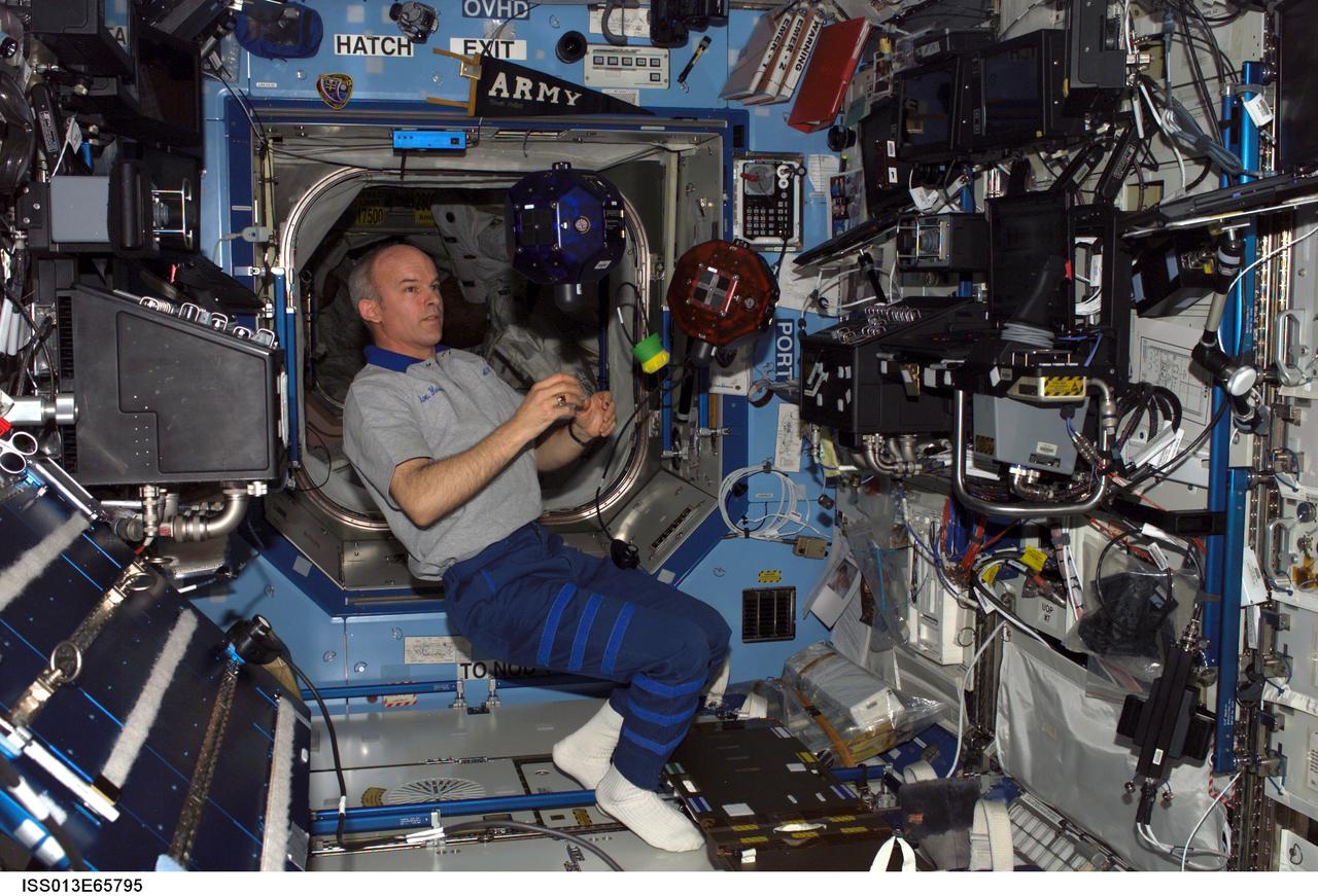 ISS013-E-65795 (12 Aug. 2006) --- Astronaut Jeffrey N. Williams, Expedition 13 NASA space station science officer and flight engineer, does a check of the Synchronized Position Hold, Engage, Reorient, Experimental Satellites (SPHERES) Beacon / Beacon Tester in the Destiny laboratory of the International Space Station.
