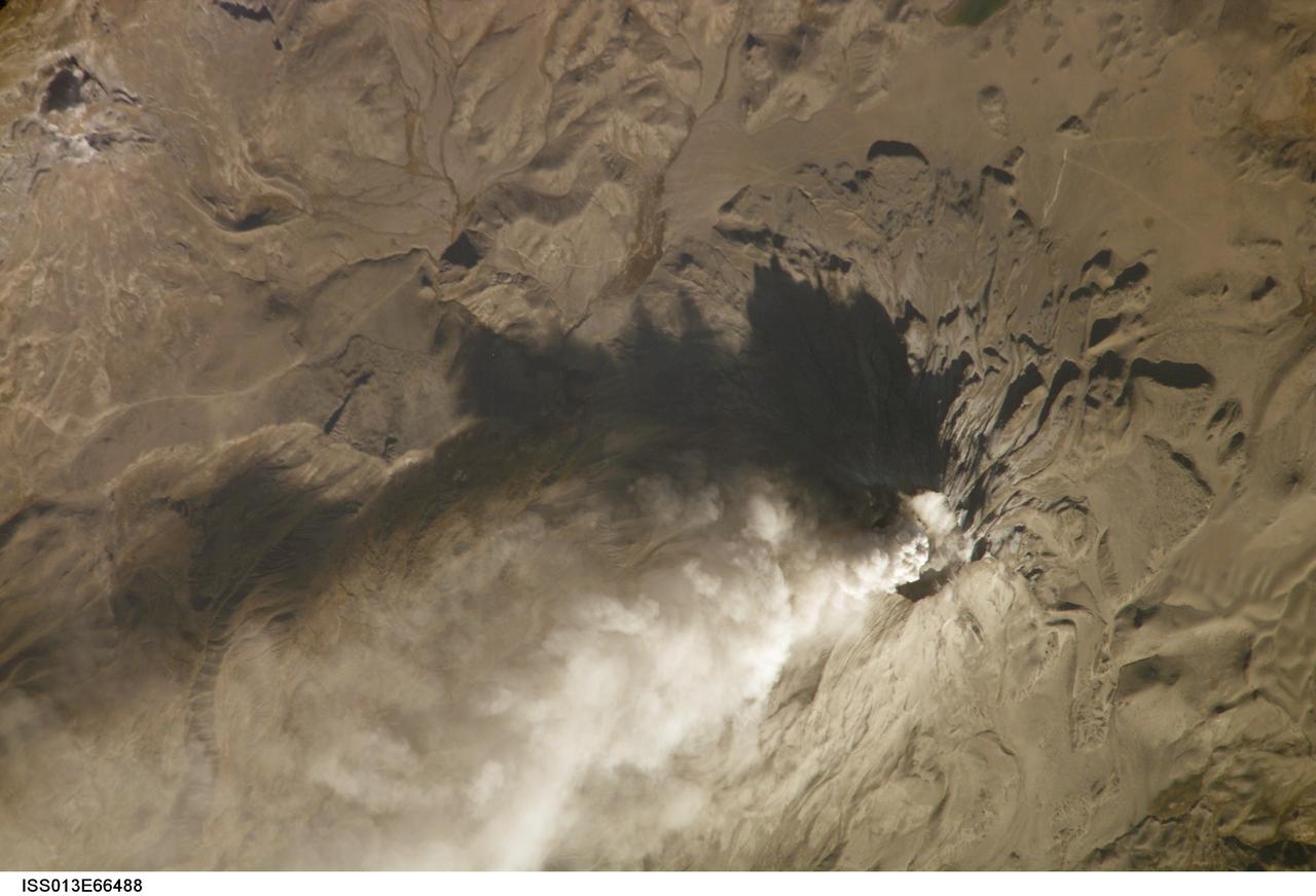 ISS013-E-66488 (14 Aug. 2006) --- Ash cloud from Ubinas Volcano, Peru is featured in this image photographed by an Expedition 13 crewmember on the International Space Station (ISS). Subduction of the Nazca tectonic plate along the western coast of South America forms the high Peruvian Andes, and also produces magma feeding a chain of historically active volcanoes along the western front of the mountains. The most active of these volcanoes in Peru is Ubinas. A typical steep-sided stratovolcano comprised primarily of layers of silica-rich lava flows, it has a summit elevation of 5,672 meters. The volcanic cone appears distinctively truncated or flat-topped in profile -- the result of a relatively small eruption that evacuated a magma reservoir near the summit. Following removal of the magma, the summit material collapsed downwards to form the current 1.4 kilometer-wide summit caldera. This oblique image (looking at an angle from the ISS) captures an ash cloud first observed on satellite imagery at 11:00 GMT on Aug. 14, 2006; this image was acquired one hour and 45 minutes later. The ash cloud resulted in the issuing of an aviation hazard warning by the Buenos Aires Volcanic Ash Advisory Center. Modern activity at Ubinas is characterized by these minor to moderate explosive eruptions of ash and larger pumice - a volcanic rock characterized by low density and high proportion of gas bubbles formed as the explosively-erupted parent lava cools during its transit through the air. These materials blanket the volcanic cone and surrounding area, giving this image an overall gray appearance. Shadowing of the western flank of Ubinas throws several lava flows into sharp relief, and highlights the steep slopes at the flow fronts -- a common characteristic of silica-rich, thick, and slow-moving lavas. NASA researchers note that the most recent major eruption of Ubinas occurred in 1969, however the historical record of activity extends back to the 16th century.