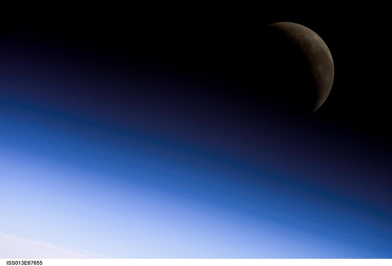 ISS013-E-67655 (18 Aug. 2006) --- A crescent moon is visible in this view of Earth's horizon and airglow, photographed by an Expedition 13 crewmember on the International Space Station.