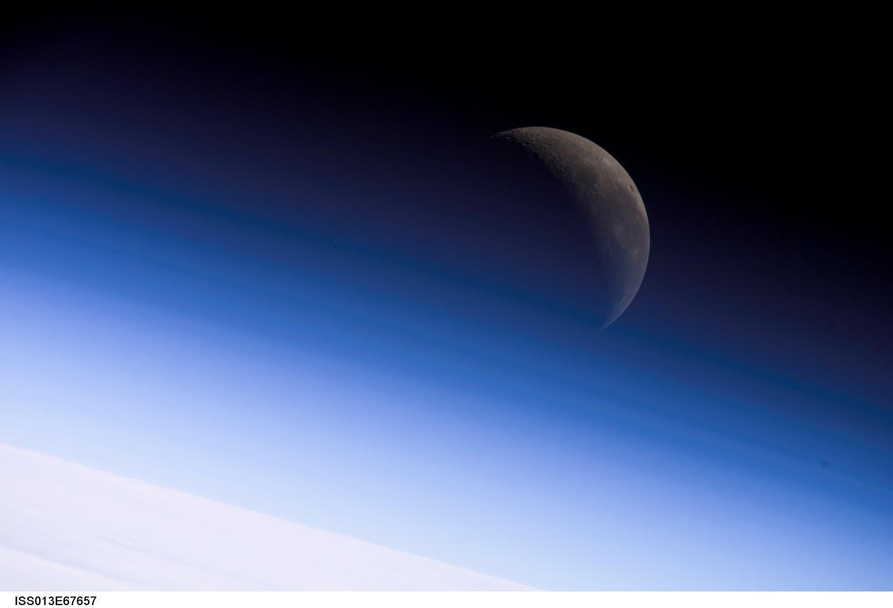 ISS013-E-67657 (18 Aug. 2006) --- A crescent moon is visible in this view of Earth's horizon and airglow, photographed by an Expedition 13 crewmember on the International Space Station.