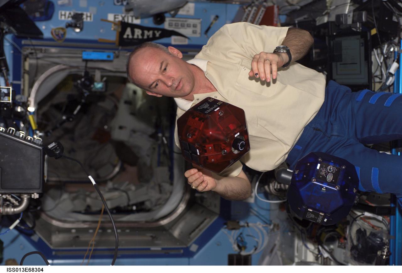 ISS013-E-68304 (19 Aug. 2006) --- Astronaut Jeffrey N. Williams, Expedition 13 NASA space station science officer and flight engineer, does a check of the Synchronized Position Hold, Engage, Reorient, Experimental Satellites (SPHERES) Beacon / Beacon Tester in the Destiny laboratory of the International Space Station.
