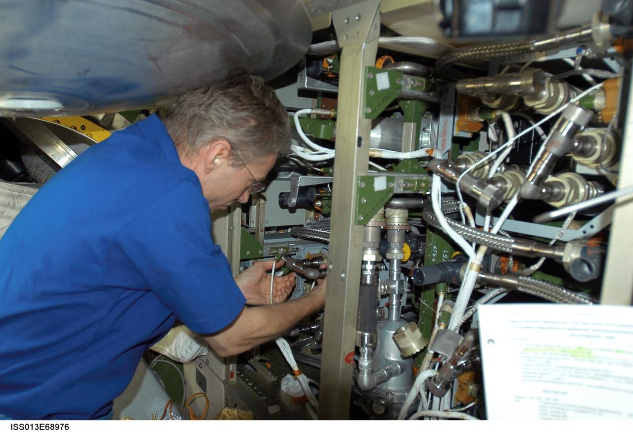 ISS013-E-68976 (August 2006) --- European Space Agency (ESA) astronaut Thomas Reiter, Expedition 13 flight engineer, works on the internal thermal cooling loop pump in the Zvezda Service Module of the International Space Station.