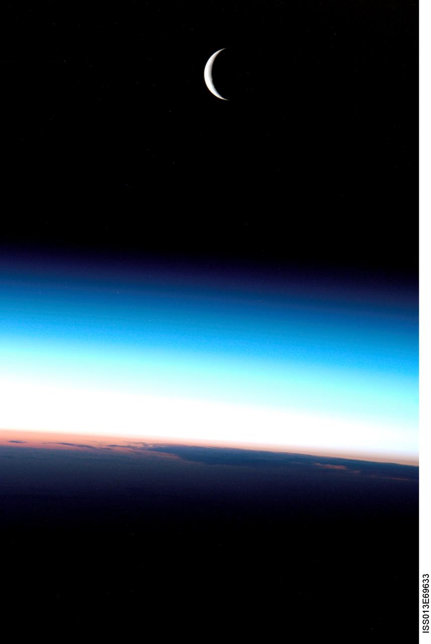 ISS013-E-69633 (August 2006) --- A crescent moon is visible in this view above Earth's horizon and airglow, photographed by an Expedition 13 crewmember on the International Space Station.