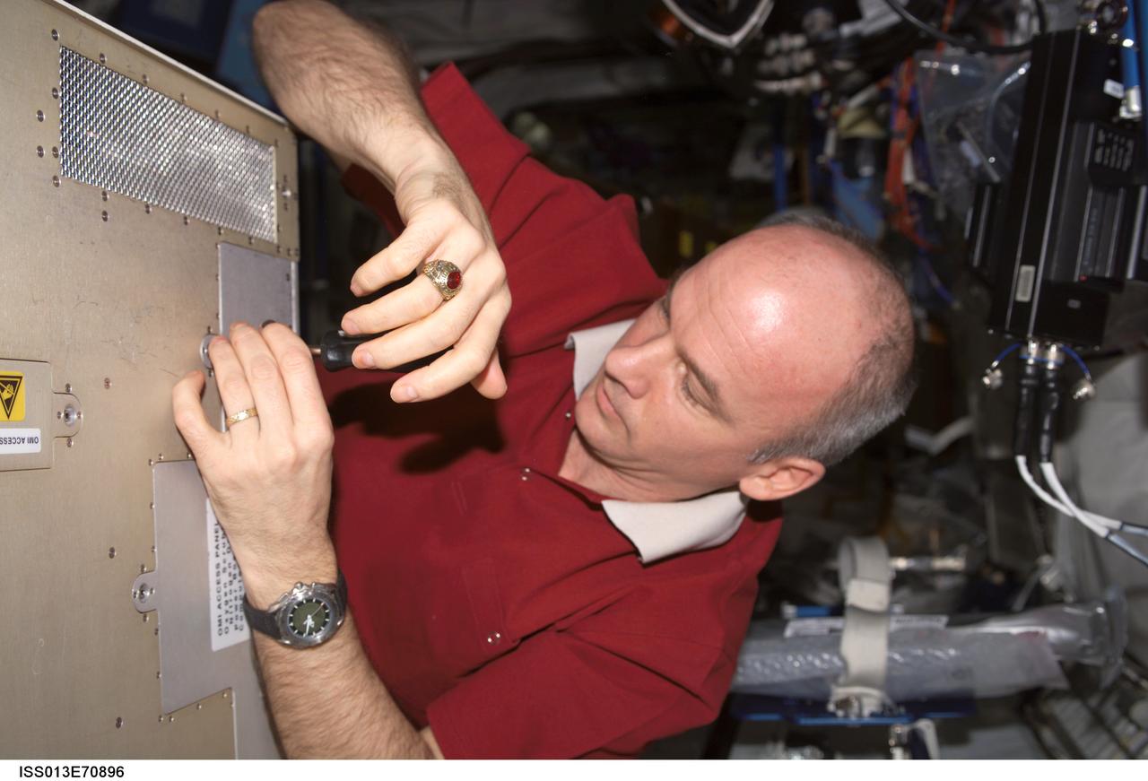 ISS013-E-70896 (24 Aug. 2006) --- Astronaut Jeffrey N. Williams, Expedition 13 NASA space station science officer and flight engineer, performs in-flight maintenance (IFM) in the Destiny laboratory of the International Space Station.
