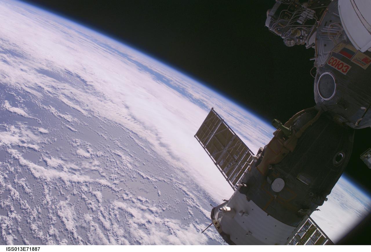 ISS013-E-71887 (28 Aug. 2006) --- Backdropped by the blackness of space and a blue and white Earth, the docked Soyuz TMA-8 spacecraft is featured in this image photographed by an Expedition 13 crewmember from a window on the International Space Station.