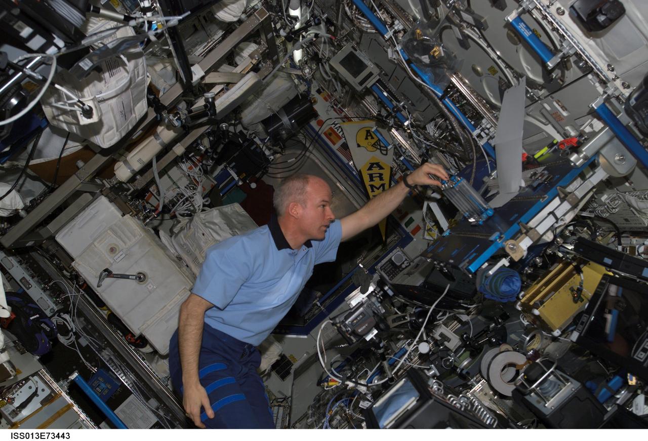 ISS013-E-73443 (30 Aug. 2006) --- Astronaut Jeffrey N. Williams, Expedition 13 NASA space station science officer and flight engineer, performs one of multiple tests of the Capillary Flow Experiment (CFE) investigation in the Destiny laboratory of the International Space Station. CFE observes the flow of fluid, in particular capillary phenomena, in microgravity.