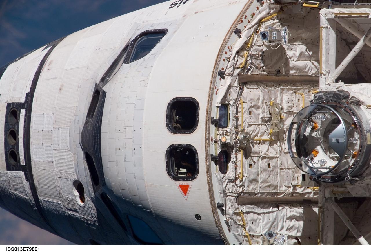 ISS013-E-79891 (11 Sept. 2006) --- This overhead image of the Space Shuttle Atlantis, recorded by a crewmember onboard the International Space Station, gives an excellent view of the top of the crew cabin and the orbiter docking system (ODS, right edge of frame). The ODS was instrumental a short while later in enabling the two spacecraft to link up for several days of joint activities for the respective crews, including the resumption of the construction of the space station.