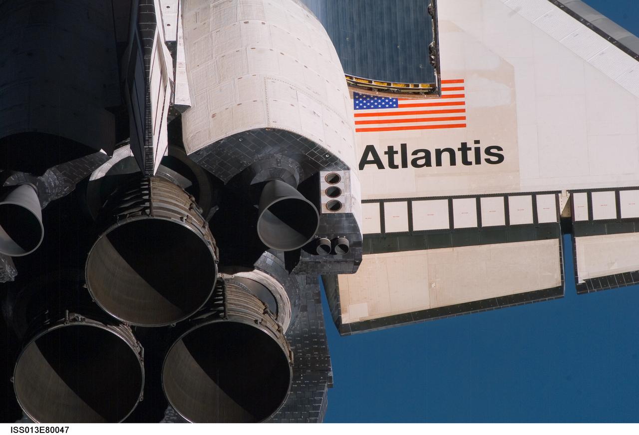 ISS013-E-80047 (11 Sept. 2006) --- A crewmember aboard the International Space Station took this picture with a handheld digital still camera as the Space Shuttle Atlantis performed a backflip while it was about 600 feet from the station during its approach. The flip, done on every shuttle mission, allows a full photographic survey of the shuttle heat shield to be taken by the station crew. This image from that survey shows the three the main engines, and part of the starboard wing and the starboard orbital maneuvering system (OMS) pod.