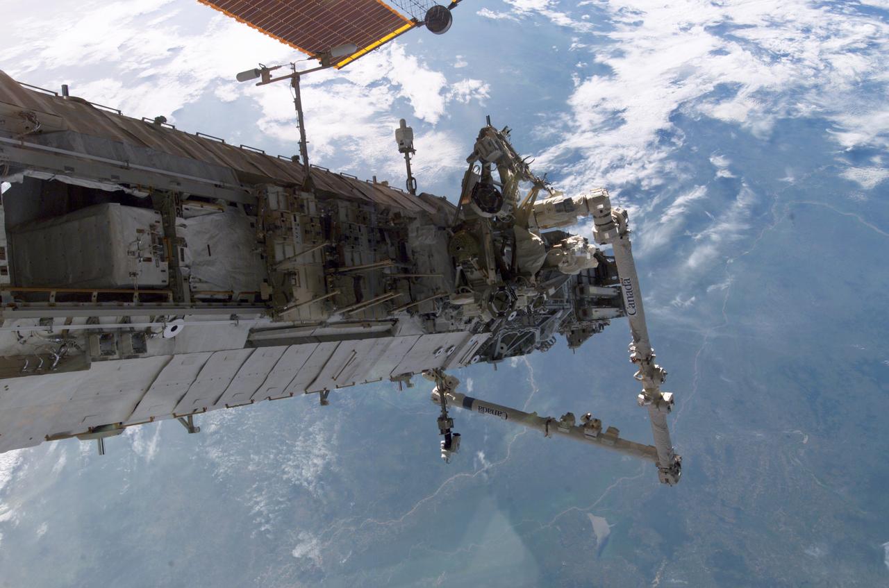 ISS013-E-80783 (12 Sept. 2006) --- Backdropped by a blue and white Earth, the new P3/P4 truss and the Canadarm2 on the International Space Station are featured in this image taken by an Expedition 13 crewmember while Space Shuttle Atlantis (STS-115) was docked with the orbital outpost.