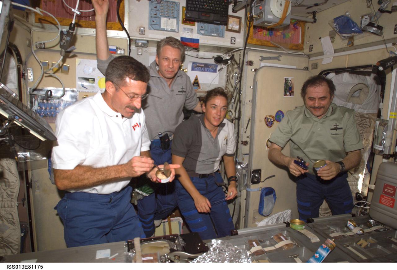 ISS013-E-81175 (13 Sept. 2006) --- Astronauts Daniel C. Burbank (left), STS-115 mission specialist; Thomas Reiter, Expedition 13 flight engineer representing the European Space Agency (ESA); Heidemarie M. Stefanyshyn-Piper, STS-115 mission specialist; and cosmonaut Pavel V. Vinogradov, Expedition 13 commander representing Russia's Federal Space Agency, share a meal in the Zvezda Service Module of the International Space Station while Space Shuttle Atlantis was docked with the station.