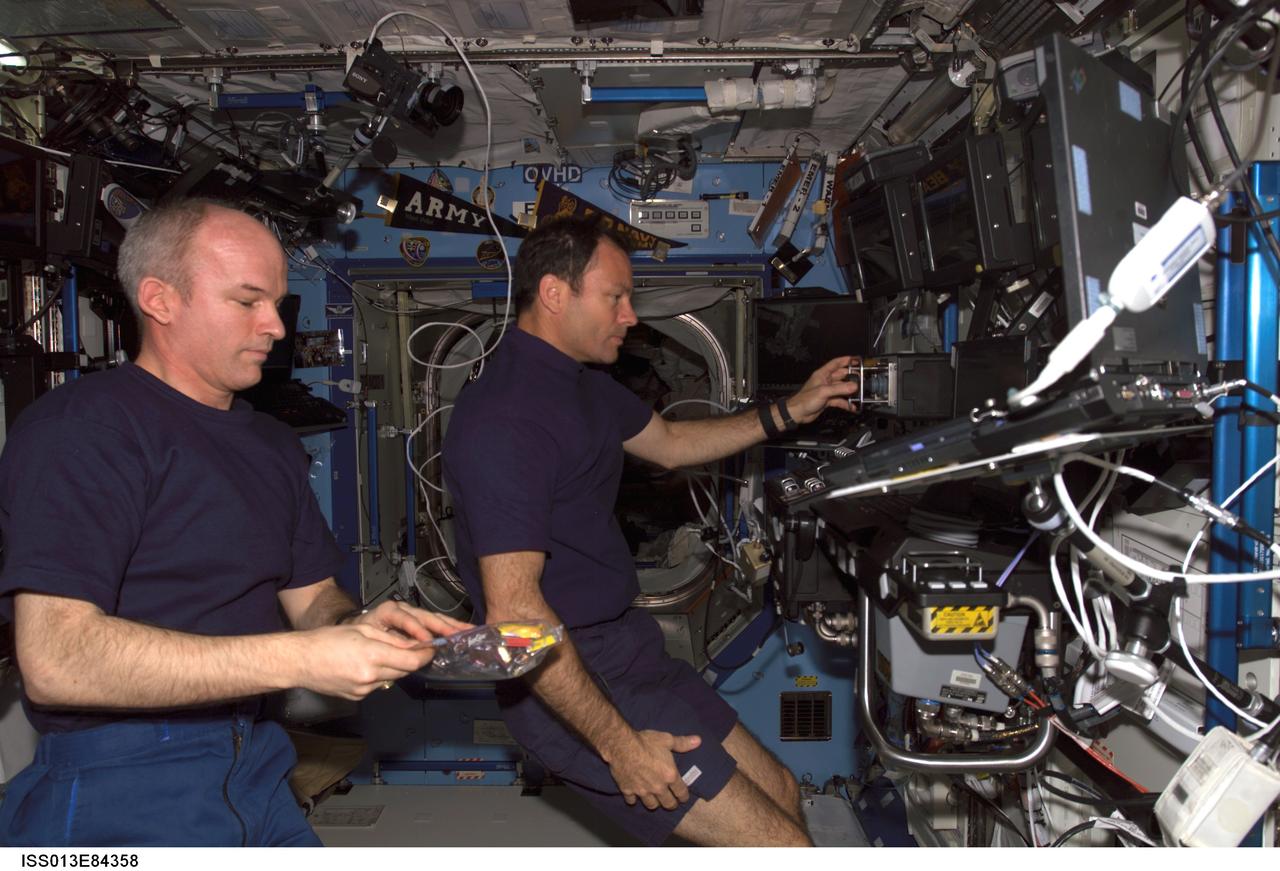 ISS013-E-84358 (26 Sept. 2006) --- Astronaut Michael E. Lopez-Alegria (right), Expedition 14 commander and NASA space station science officer, works at the Space Station Remote Manipulator System (SSRMS) or Canadarm2 workstation in the Destiny laboratory of the International Space Station. Astronaut Jeffrey N. Williams, Expedition 13 NASA space station science officer and flight engineer, is at left.