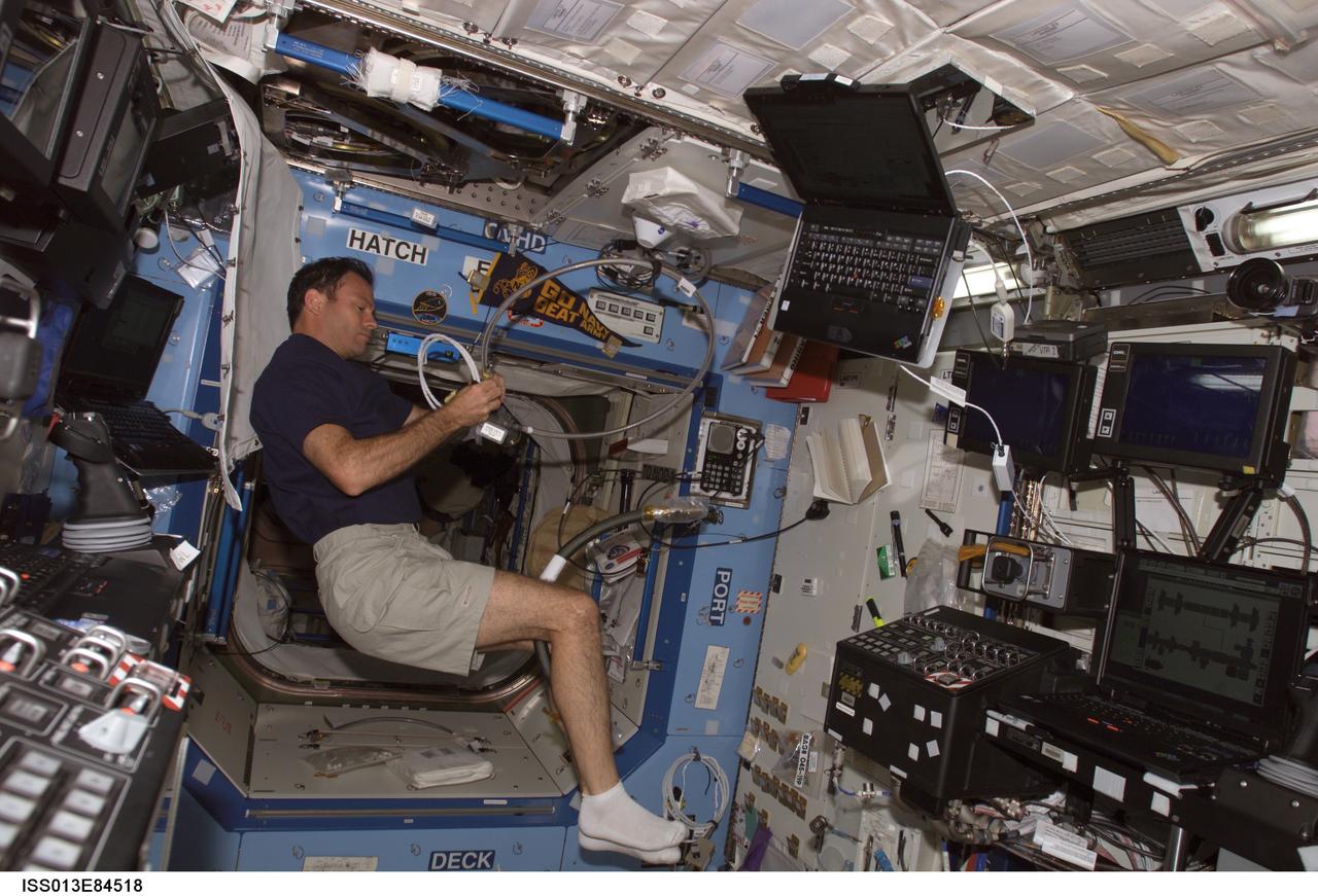 ISS013-E-84518 (27 Sept. 2006) --- Astronaut Michael E. Lopez-Alegria, Expedition 14 commander and NASA space station science officer, works with cables in the Destiny laboratory of the International Space Station.