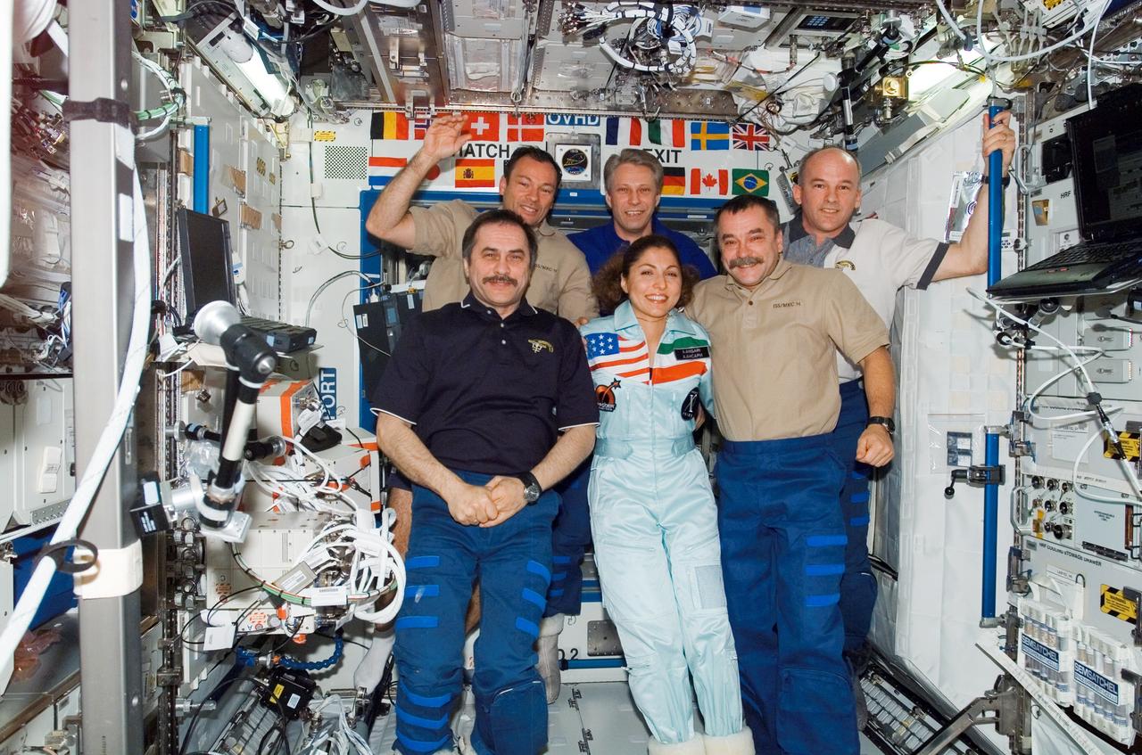 ISS013-E-84574 (27 Sept. 2006) --- The crewmembers onboard the International Space Station pose for a group photo in the Destiny laboratory. From the left (front row) are cosmonaut Pavel V. Vinogradov, Expedition 13 commander representing Russia's Federal Space Agency; spaceflight participant Anousheh Ansari; and cosmonaut Mikhail Tyurin, Expedition 14 flight engineer representing Russia's Federal Space Agency. From the left (back row) are astronaut Michael E. Lopez-Alegria, Expedition 14 commander and NASA space station science officer; European Space Agency (ESA) astronaut Thomas Reiter, Expedition 13/14 flight engineer; and astronaut Jeffrey N. Williams, Expedition 13 NASA space station science officer and flight engineer.