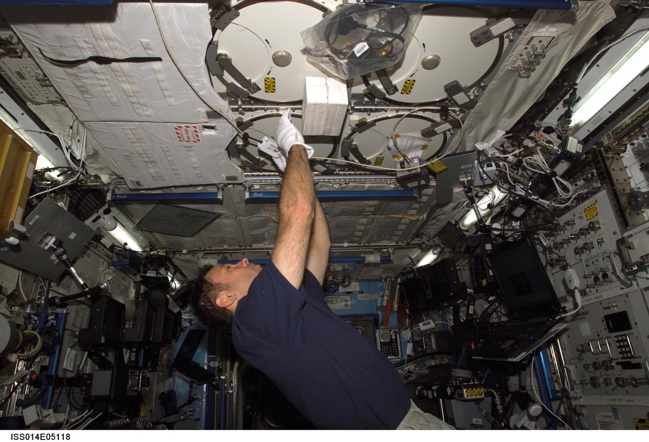ISS014-E-05118 (3 Oct. 2006) --- Astronaut Michael E. Lopez-Alegria, Expedition 14 commander and NASA space station science officer, works with the Passive Observatories for Experimental Microbial Systems in Micro-G (POEMS) payload in the Minus Eighty Degree Laboratory Freezer for ISS (MELFI) in the Destiny laboratory of the International Space Station. MELFI is a low temperature freezer facility with nominal operating temperatures of -80, -26 and +4 degrees Celsius that will preserve experiment materials over long periods.